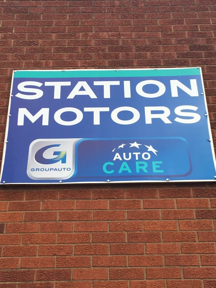 Station Motors sign with the Groupauto and Auto Care logos on the workshop wall
