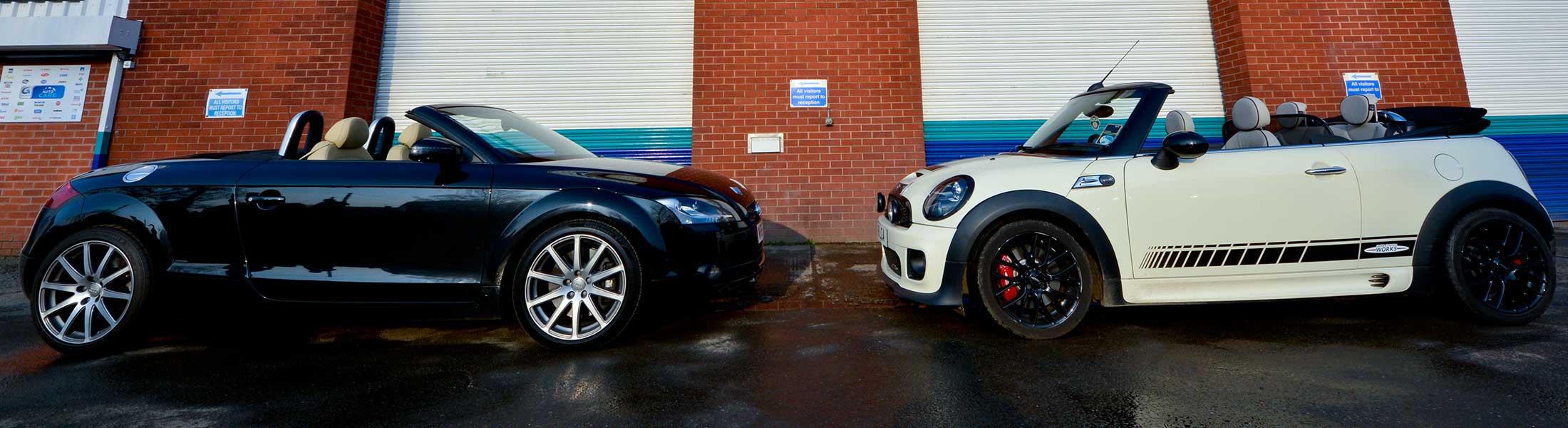 An Audi TT and a Mini convertible parked outside the Station Motors workshop